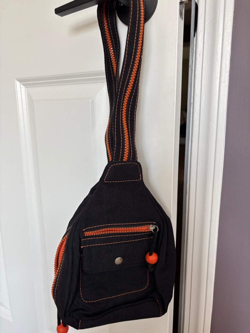 Black and Orange woman’s sling/backpack with Contrast Stitching
